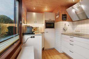 a small kitchen with white cabinets and a window at Frenkhausener Ruhepol in Meschede +17 photos