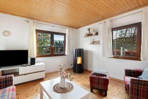 a living room with a tv and a couch and a table at Frenkhausener Ruhepol in Meschede