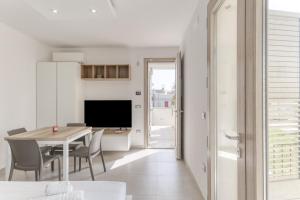 a kitchen and dining room with a table and chairs at Appartamenti a 50 m dal mare in Torre San Giovanni Ugento
