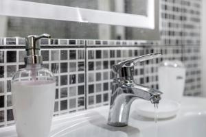 a bathroom sink with a glass bottle of soap at Pico The Best View in Ribeira Brava +17 photos