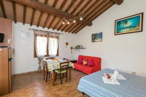a living room with a table and a red couch at Il Pino - monolocale Lavanda in Cecina