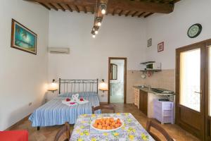 a room with a bed and a table with a bowl of fruit on it at Il Pino - monolocale Lavanda in Cecina +16 photos