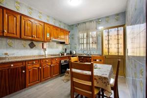 a kitchen with wooden cabinets and a table with a tableablish at Pico The Best View in Ribeira Brava