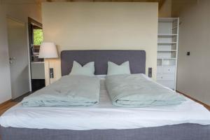 a large bed with white sheets and pillows at Haus Lichtenstern in Soprabolzano