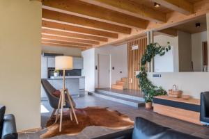 a living room with wooden ceilings and a table with a lamp at Haus Lichtenstern in Soprabolzano