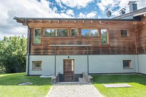 a house with a wooden facade with a door at Haus Lichtenstern in Soprabolzano