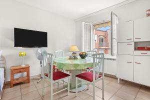a kitchen with a table with chairs and a tv at Appartement à deux pas de la mer in Fréjus