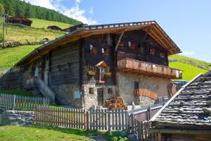 an old house with a fence in front of it at Untervernatsch Fewo Edelweiss in Senales