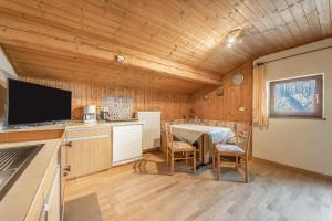 a kitchen and dining room with a table and a television at Untervernatsch Fewo Edelweiss in Senales