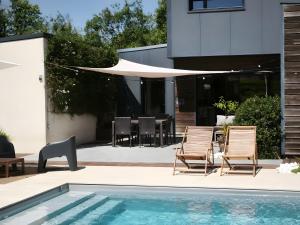 a patio with two chairs and a swimming pool at La Fée Maison, chambres d'hôtes in Plouër-sur-Rance