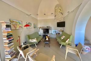 a living room with green chairs and a fireplace at Dammuso Civulia Pantelleria in Pantelleria