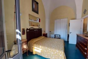 a bedroom with a bed and a dresser and a refrigerator at Dammuso Civulia Pantelleria in Pantelleria