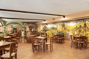 a restaurant with tables and chairs and a mural at Appartamento Iris in Cisterna dʼAsti