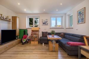 a living room with a couch and a tv at Ferienwohnung Tannenblick in Höchst