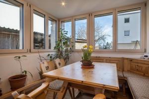 a kitchen with a table and chairs and windows at Ferienwohnung Tannenblick in Höchst