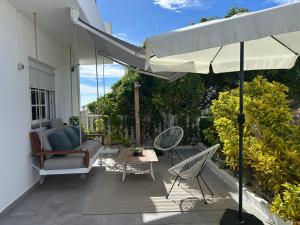 a patio with an umbrella and chairs and a table at Casa Alba in Lomo de Arico