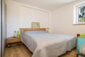 a bedroom with a bed and a wooden night stand at Ferienwohnung Tannenblick in Höchst