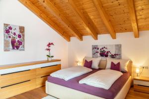 two beds in a bedroom with wooden ceilings at Bletschers Hoamat in Mittenwald