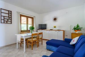 a living room with a table and a blue couch at Foxi lioni in Tertenìa