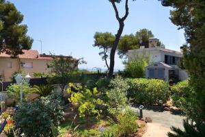 a garden in front of a house with trees at Ethel in Castelldefels