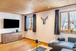 a living room with a couch and a flat screen tv at Bletschers Hoamat in Mittenwald