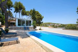 a swimming pool in front of a house at Ethel in Castelldefels
