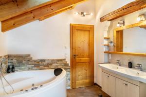 a bathroom with a tub and a sink and a mirror at Bletschers Hoamat in Mittenwald +32 photos