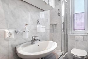 a white bathroom with a sink and a toilet at Auszeit Schwarzwald in Furtwangen +21 photos