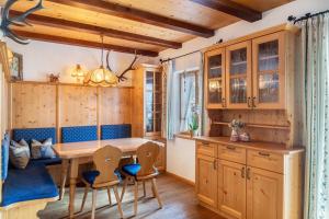 a kitchen with wooden cabinets and a table and chairs at Bletschers Hoamat in Mittenwald