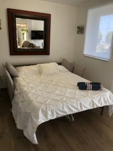a white bed in a bedroom with a mirror at Ethel in Castelldefels +18 photos