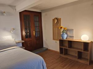 a bedroom with a bed and a vase of flowers on a table at Casa Corral Bouzamayor in Valdoviño +37 photos