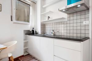 a white kitchen with a sink and a window at Haus Marlene in Cornedo all'Isarco +15 photos