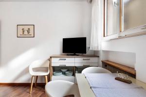 a living room with a tv and a table and chairs at Haus Marlene in Cornedo all'Isarco