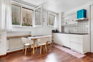 a kitchen with white cabinets and a wooden table and chairs at Haus Marlene in Cornedo all'Isarco