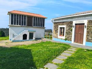 a house with a door and a grass yard at Casa Corral Bouzamayor in Valdoviño