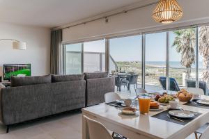 a living room with a couch and a table with food at Beachfront Atlantic View A09 in Óbidos