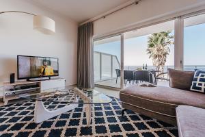 a living room with a couch and a glass table at Beachfront Atlantic View A09 in Óbidos