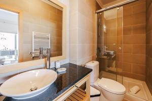 a bathroom with a sink and a toilet and a shower at Beachfront Atlantic View A09 in Óbidos +7 photos