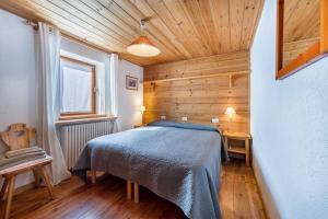 a bedroom with a bed and a wooden ceiling at Chalet complet in Antey-Saint-André