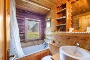 a bathroom in a log cabin with a tub and a sink at Chalet complet in Antey-Saint-André +23 photos