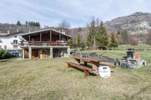 a house with a picnic table in front of it at Chalet complet in Antey-Saint-André