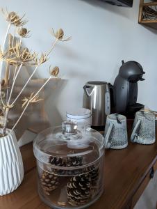 a counter with a glass jar of pine cones at La Fée Maison, chambres d'hôtes in Plouër-sur-Rance
