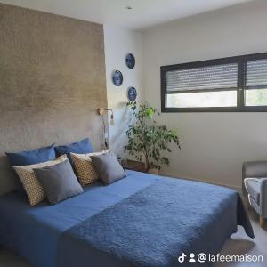 a bedroom with a bed with blue sheets and a window at La Fée Maison, chambres d'hôtes in Plouër-sur-Rance +39 photos