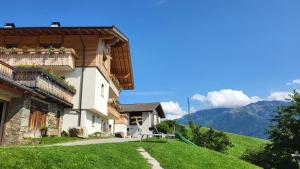 a house on the side of a hill with mountains at Bergsteiger Apartment - Patleidhof in Naturno