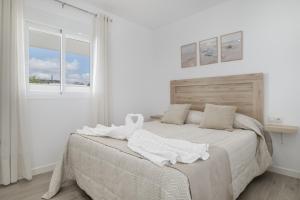 a white bedroom with a large bed with white sheets at Villa Laruma in Cádiz +14 photos