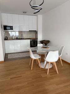 a kitchen with a table and two chairs and a table at Bagdala apartman Krusevac in Kruševac