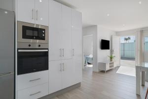 a kitchen with white cabinets and a stove at Villa Laruma in Cádiz