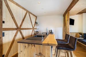 a kitchen with wooden walls and a counter with a sink at Bergsteiger Apartment - Patleidhof in Naturno