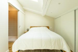 a bedroom with a white bed and a shower at Duplex Curistes - Conciergerieland in Dax