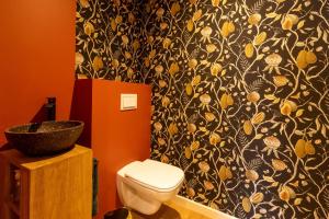 a bathroom with a toilet and a black and yellow wallpaper at Duplex Curistes - Conciergerieland in Dax +14 photos